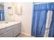 Bathroom with vanity, sink, mirror, gray cabinets and blue shower curtain at 4020 Cranwood Dr, Atlanta, GA 30349