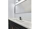 Close up of modern bathroom vanity featuring sleek mirror, black faucet, and white countertop at 459 Orchard Dr, Stone Mountain, GA 30083