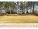 View of a spacious, green backyard surrounded by mature trees and privacy fence at 107 Grand Ave, Suwanee, GA 30024