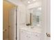 Bathroom with a white vanity, storage cabinet, and a mirror; door opening to the shower and bathtub at 107 Grand Ave, Suwanee, GA 30024