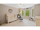 Comfortable bedroom with a crib, glider, and bright windows overlooking the green landscape at 107 Grand Ave, Suwanee, GA 30024