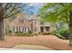 Charming two-story brick home with a beautifully landscaped front yard, accented by mature trees and a manicured lawn at 107 Grand Ave, Suwanee, GA 30024