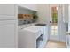 Well-lit laundry room with washer, dryer, cabinets and outdoor access at 107 Grand Ave, Suwanee, GA 30024