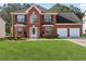Charming two-story red brick home with a well-manicured lawn and a two-car garage at 192 Palisade Point Dr, Ellenwood, GA 30294