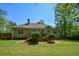 A spacious lawn leads up to the rear of the home with its deck and patio, surrounded by trees at 210 Mels Way, Stockbridge, GA 30281