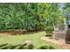 Lush backyard view featuring a wooden deck and mature trees, creating a private and peaceful outdoor space at 210 Mels Way, Stockbridge, GA 30281