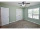 Comfortable bedroom with neutral carpet, a ceiling fan, and double closets at 210 Mels Way, Stockbridge, GA 30281