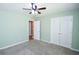 Well-lit bedroom featuring a ceiling fan, neutral carpet, and a view into the hallway at 210 Mels Way, Stockbridge, GA 30281