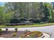 Welcoming Melrose community entrance featuring manicured landscaping and brick signage under mature trees at 210 Mels Way, Stockbridge, GA 30281