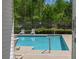 View of the community swimming pool with lounge chairs and mature trees, as seen through a doorway at 210 Mels Way, Stockbridge, GA 30281