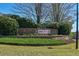 Community entrance sign with 'Melrose' name against a backdrop of manicured landscaping and mature trees at 210 Mels Way, Stockbridge, GA 30281