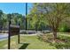 Community tennis court area with guest code of conduct sign and surrounding green landscape at 210 Mels Way, Stockbridge, GA 30281