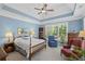 Serene bedroom featuring a tray ceiling, large window, wood furniture, and a cozy armchair at 7425 Twin Creek Ct, Cumming, GA 30041