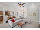 Comfortable living room boasts a large sectional sofa, neutral walls, ceiling fan, and views into the kitchen and front entry at 7425 Twin Creek Ct, Cumming, GA 30041