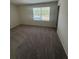 Bright carpeted bedroom featuring a window with blinds offering scenic outdoor views at 87 Sonoma Drive, Dallas, GA 30157