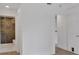 Hallway leading to a bathroom, hardwood floors, and fresh white paint at 1075 Peachtree Ne Walk # A421, Atlanta, GA 30309