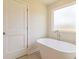 Elegant bathroom features a freestanding tub, a window, and neutral tones creating a relaxing atmosphere at 208 Crabapple St, Mcdonough, GA 30253