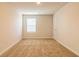 Bright, carpeted bedroom featuring a window and neutral paint, creating a serene atmosphere at 208 Crabapple St, Mcdonough, GA 30253