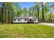 Charming single-story home featuring a well-manicured lawn and beautiful trees surrounding the property at 2798 Hutchins Rd, Lawrenceville, GA 30044