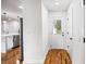 Hallway with hardwood floors with white doors and trim leading to the kitchen, complete with a stainless-steel refrigerator at 2798 Hutchins Rd, Lawrenceville, GA 30044