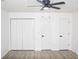 Neutral bedroom featuring new wood floor and three white paneled doors at 6737 Mason Creek Rd, Douglasville, GA 30135