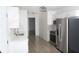 Modern kitchen features white cabinets, marble-look backsplash, stainless steel appliances, and wood-look floors at 6737 Mason Creek Rd, Douglasville, GA 30135