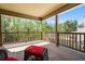 Enjoy the view from this home's covered back deck with wood railings and a wicker chair at 1041 Sweetwater Bridge Cir, Douglasville, GA 30134