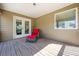 Covered back deck features wood floors, a wicker chair, and backyard views at 1041 Sweetwater Bridge Cir, Douglasville, GA 30134
