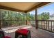 Enjoy the view from this home's covered back deck with wood railings and a wicker chair at 1041 Sweetwater Bridge Cir, Douglasville, GA 30134