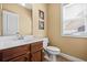 Half bathroom featuring vanity with white sink, artwork, toilet, and window at 1041 Sweetwater Bridge Cir, Douglasville, GA 30134