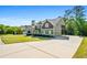 Exterior shot of a two-story home with manicured lawn and a large paved driveway at 1041 Sweetwater Bridge Cir, Douglasville, GA 30134