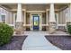 Inviting front porch with stone accents, columns, and a stylish glass door at 1041 Sweetwater Bridge Cir, Douglasville, GA 30134