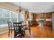Sunlit dining area with a chandelier that flows into kitchen with wood cabinetry at 1041 Sweetwater Bridge Cir, Douglasville, GA 30134