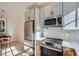 Modern kitchen featuring stainless steel appliances, tile backsplash, and light-colored cabinets at 301 10Th Ne St # 3, Atlanta, GA 30309