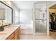 Bright bathroom featuring a glass-enclosed shower, soaking tub, and access to a walk-in closet at 3501 Chattahoochee Summit Se Ln, Atlanta, GA 30339