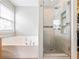 This bathroom offers a soaking tub and a glass-enclosed shower with tiled walls and floors at 3501 Chattahoochee Summit Se Ln, Atlanta, GA 30339