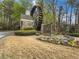 Stone community sign surrounded by flowers, shrubs, and mature landscaping near the entrance at 3501 Chattahoochee Summit Se Ln, Atlanta, GA 30339