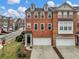 Brick townhome featuring a two-car garage and black front door at 3501 Chattahoochee Summit Se Ln, Atlanta, GA 30339