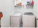 Functional laundry room with a washer, dryer, shelving, and storage for cleaning supplies at 3501 Chattahoochee Summit Se Ln, Atlanta, GA 30339