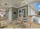 Inviting covered porch with stone flooring, ceiling fan, and comfortable rocking chairs overlooking the pool at 3501 Chattahoochee Summit Se Ln, Atlanta, GA 30339