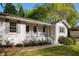 View of the inviting exterior with its classic white brick, gray shutters, and covered porch entrance to home at 5132 Foxwood Ct, Atlanta, GA 30360