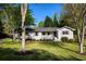 Charming white brick home featuring a well-manicured lawn and beautiful mature trees in a lovely front yard at 5132 Foxwood Ct, Atlanta, GA 30360