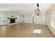 Open-concept living room with a brick fireplace, wood mantle, natural light, and stylish lighting fixture at 5132 Foxwood Ct, Atlanta, GA 30360