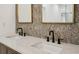 Double sink vanity features quartz countertop, matte black faucets, and decorative wallpaper at 878 Dill Sw Ave, Atlanta, GA 30310