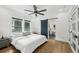 Serene bedroom with hardwood floors, neutral tones, modern fan, and a barn door leading to the bathroom at 878 Dill Sw Ave, Atlanta, GA 30310