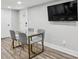 Bright dining area featuring wood flooring, a modern table with seating, and a large wall-mounted television at 878 Dill Sw Ave, Atlanta, GA 30310