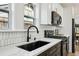 Close-up of a kitchen sink with black faucet and white countertop with tile backsplash at 878 Dill Sw Ave, Atlanta, GA 30310