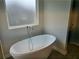 Bright bathroom featuring a luxurious free-standing soaking tub at 1594 Sungrown Way, Mcdonough, GA 30253