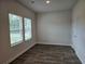 A minimalist bedroom with wood-look flooring and natural light from large windows at 1594 Sungrown Way, Mcdonough, GA 30253