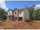New construction home with a two-car garage, brick and tan siding, and an unfinished lawn at 1594 Sungrown Way, Mcdonough, GA 30253